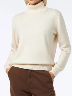 Frau hat einen weißen Rollkragenpullover gestrickt