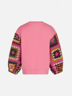 Rosa Mädchenpullover mit Häkelärmeln
